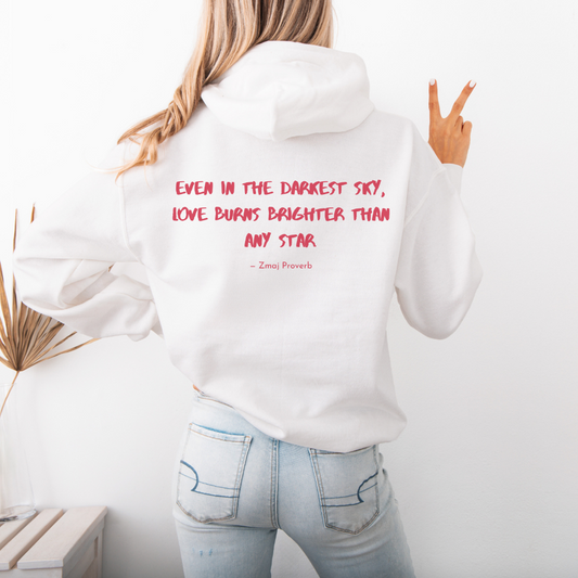 Person wearing a white hoodie with a motivational quote on the back, standing against a plain background.