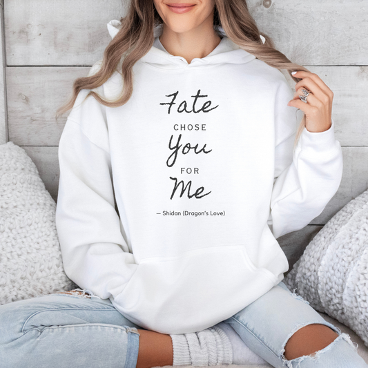 Person wearing a white hoodie with text, sitting on a wooden floor.