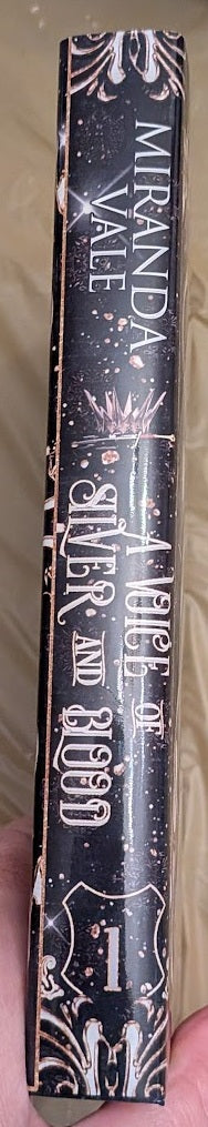 Book titled 'A Voice of Blood' by Miranda Yale held in hand